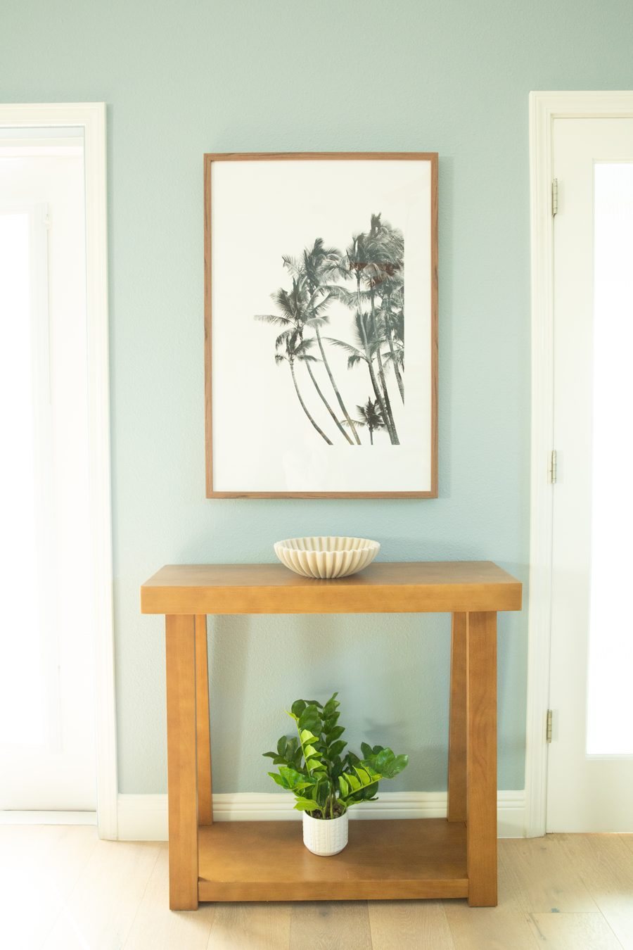 Palm tree print over a wood console table