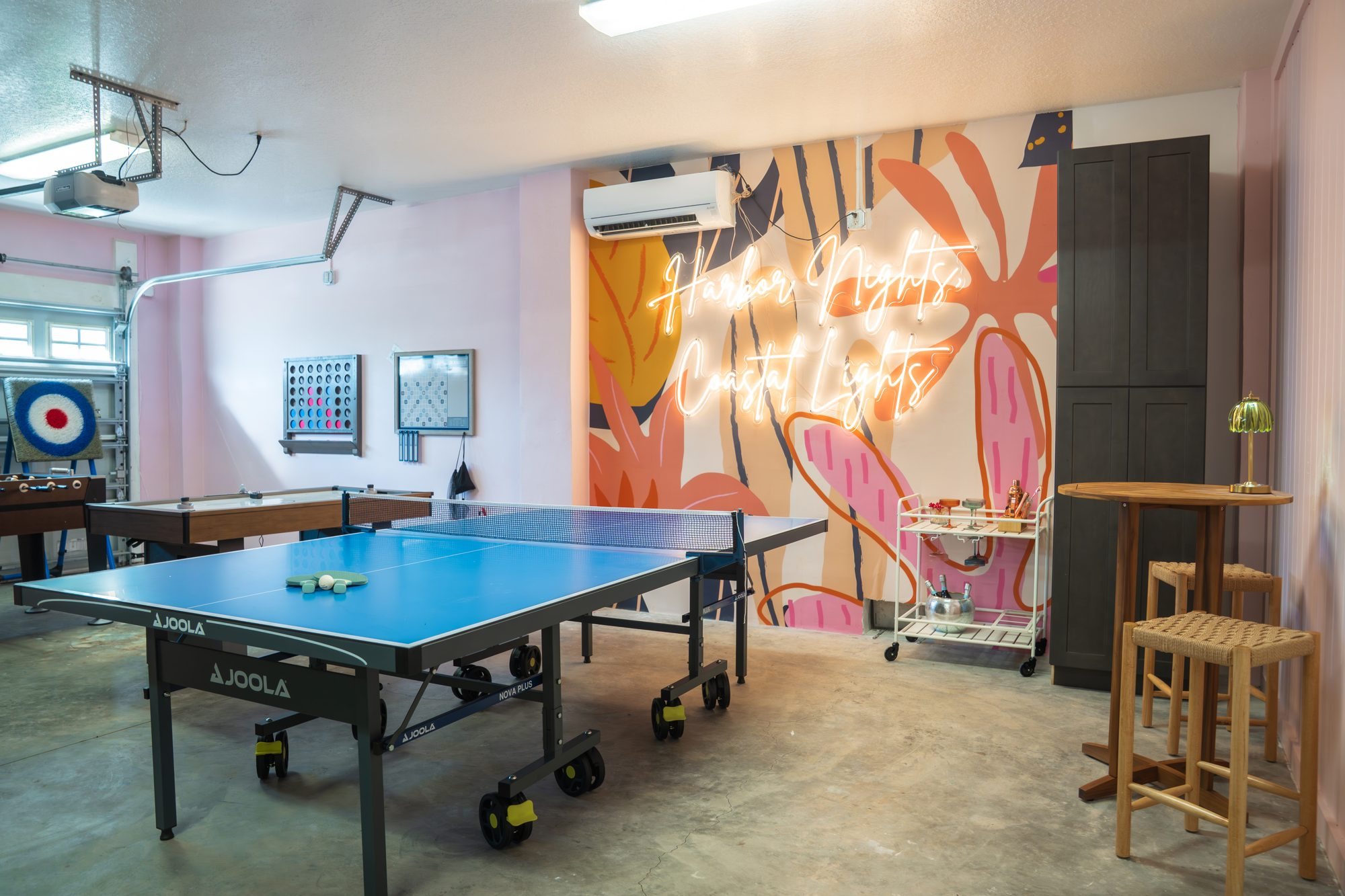 Downstairs game room with ping pong, air hockey, foosball and the Harbor Nights neon sign