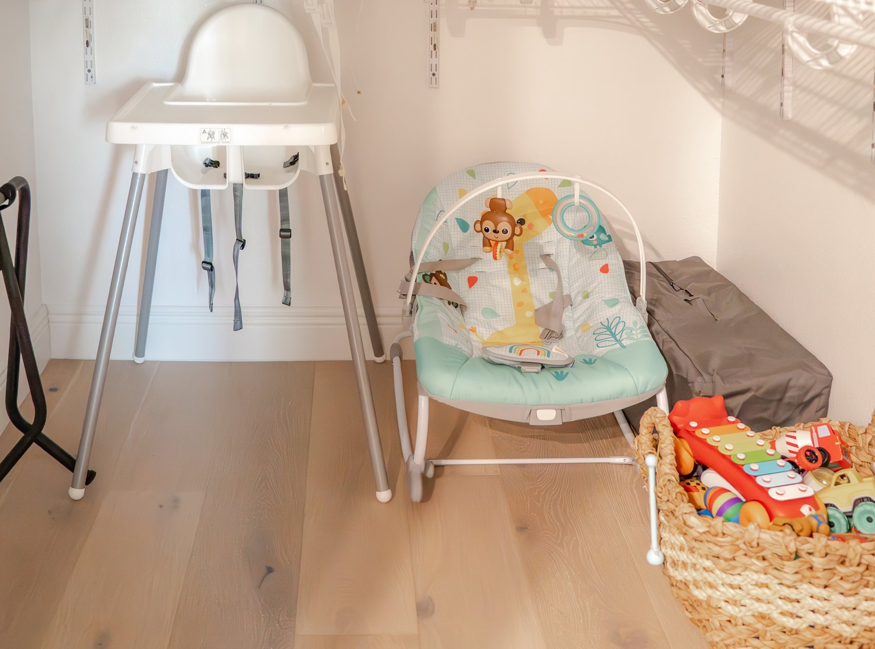 High chair, baby bouncer, travel crib and a basket of toys ready for little guests