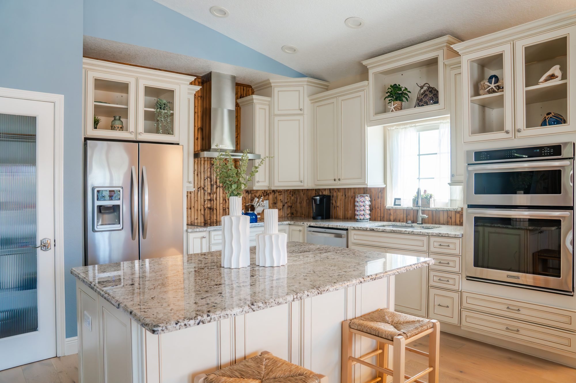 Kitchen with granite island, stainless appliances and double wall ovens