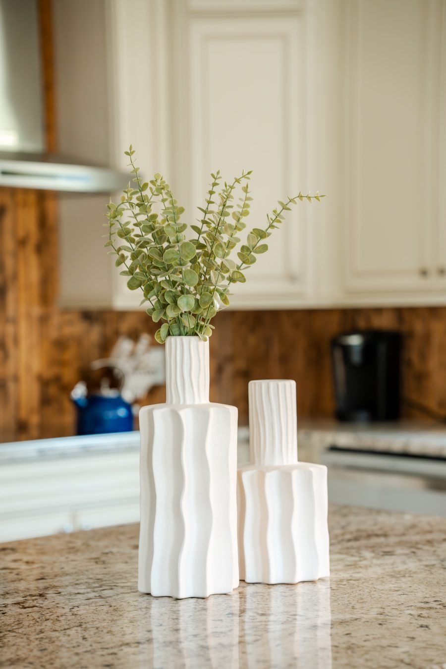 White ceramic vases with eucalyptus on the kitchen island