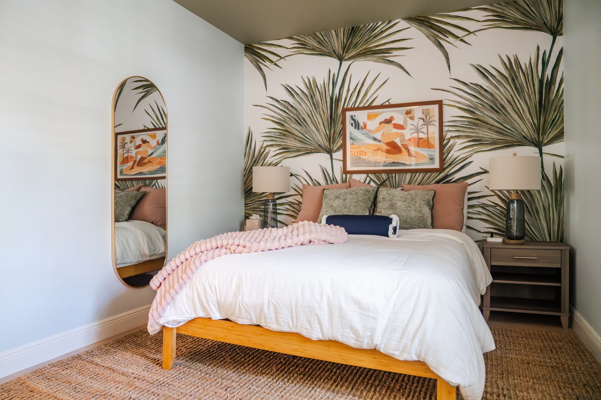 Bedroom 2 with queen bed, palm leaf wallpaper and surf art